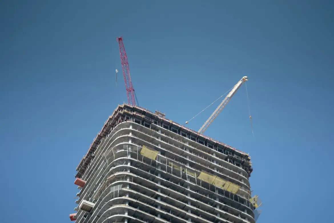Cranes on top of a highrise tower