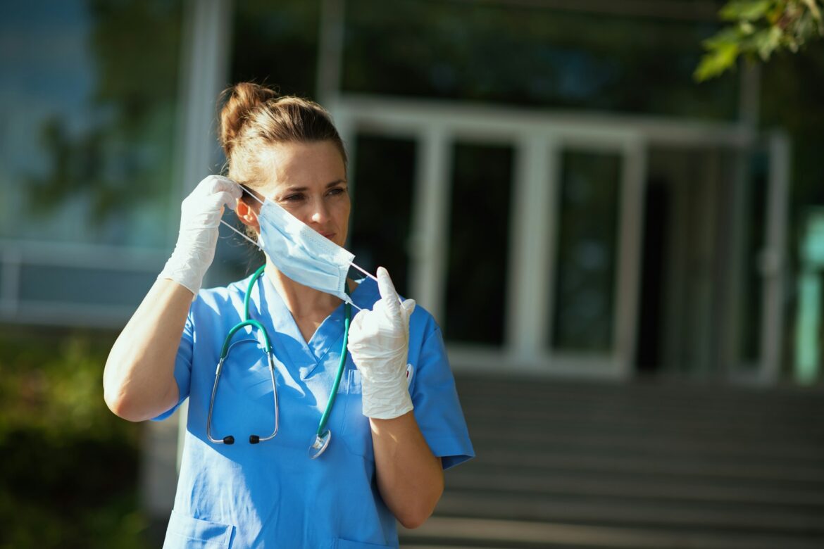 Nurse taking off her face mask