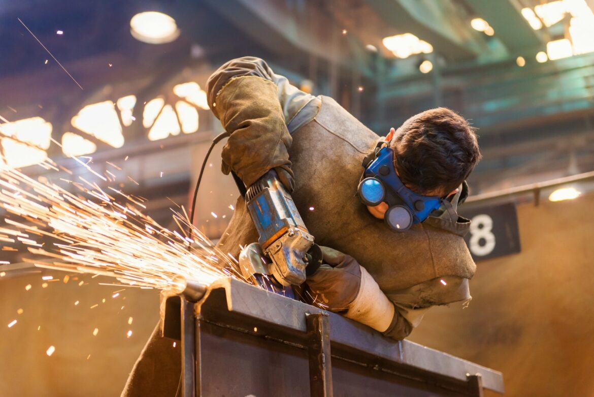 Young man with protective goggles welding